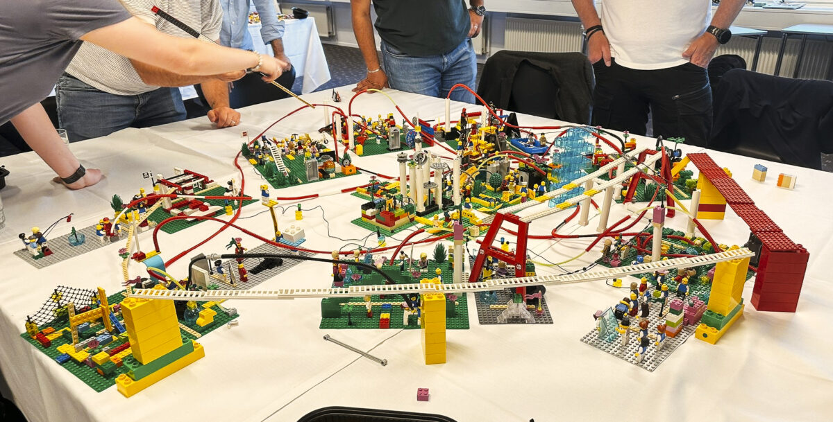Professionals collaborating around a table filled with LEGO® sculptures during a SeriousPlay® session.