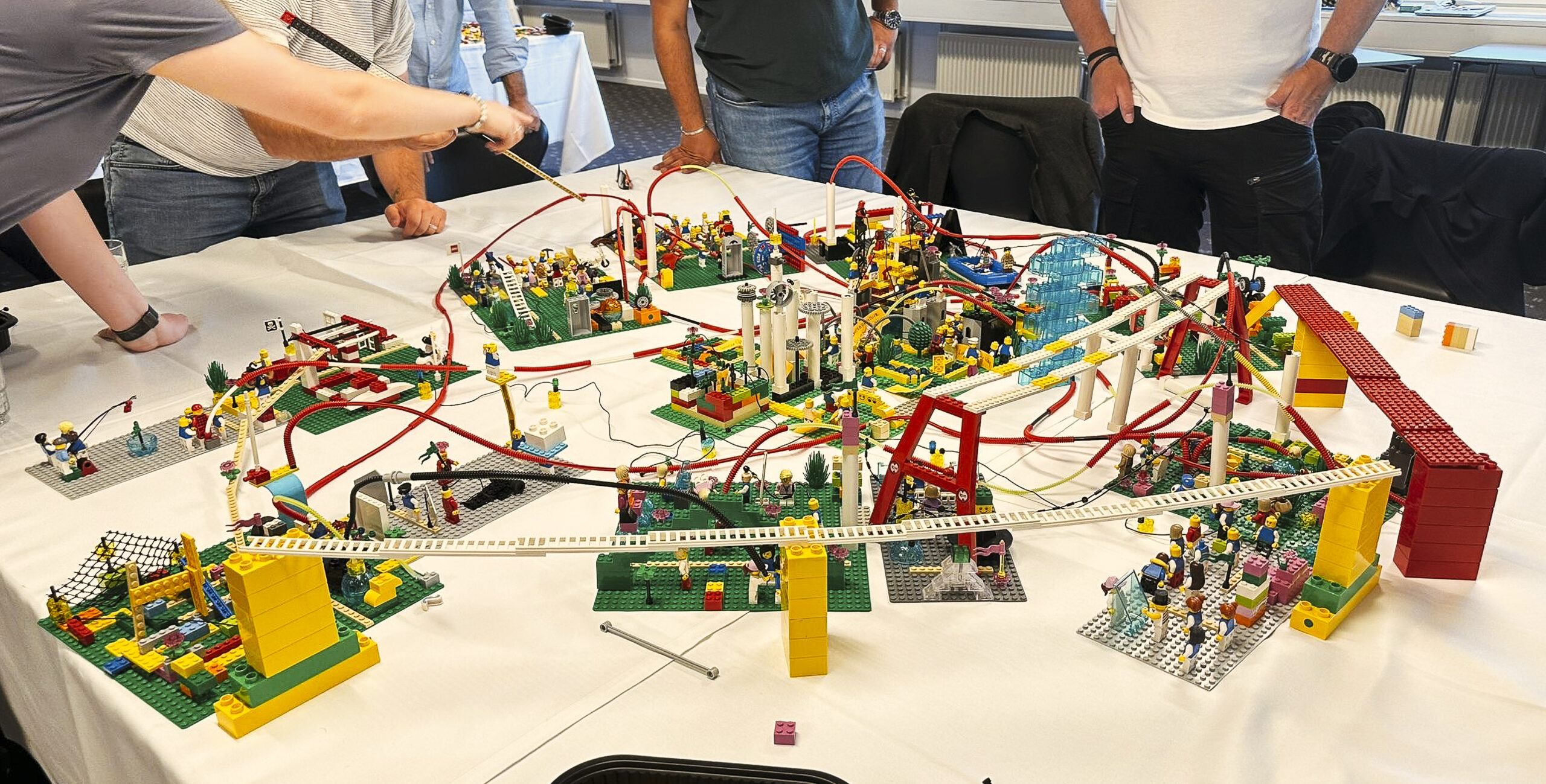 Professionals collaborating around a table filled with LEGO® sculptures during a SeriousPlay® session.