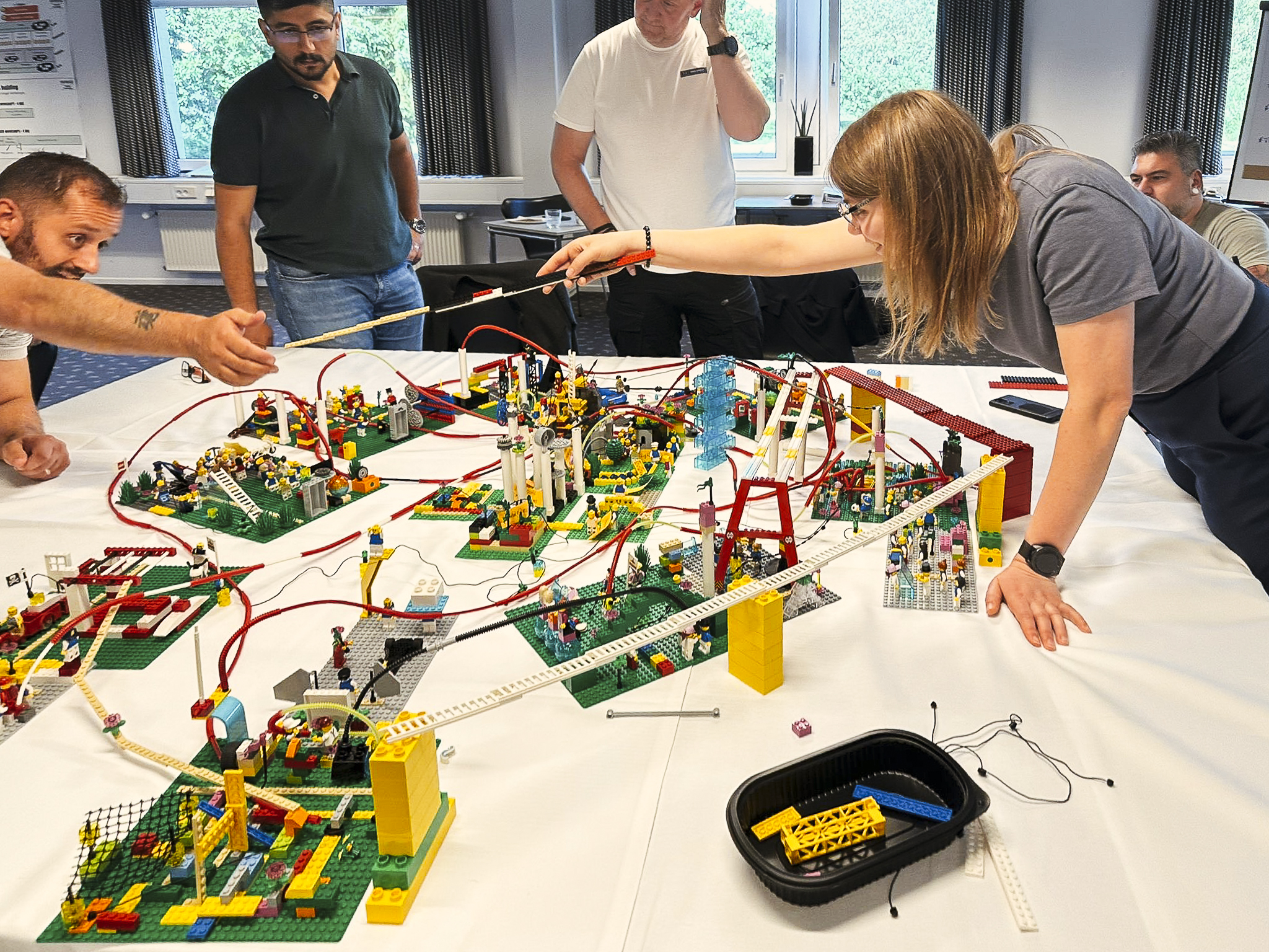 Participants intensely collaborating over LEGO® models during a workshop on customer-centric innovation.