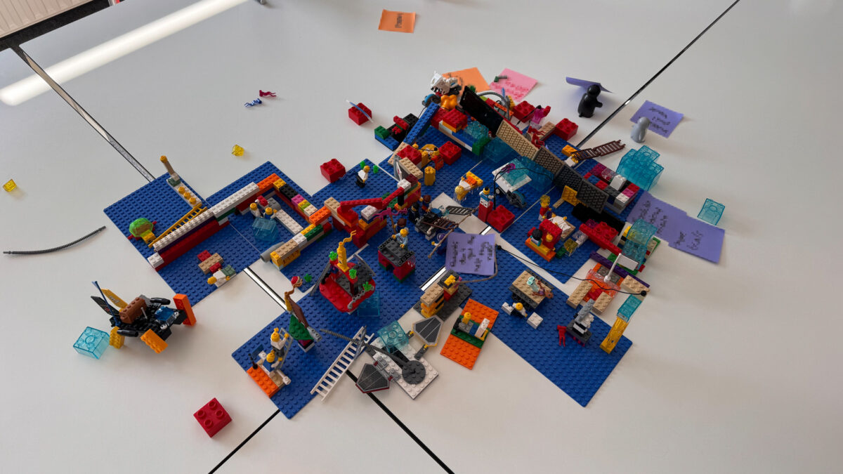 Shared LEGO Serious Play landscape showing interconnected models, barriers and dependencies on blue baseplates.